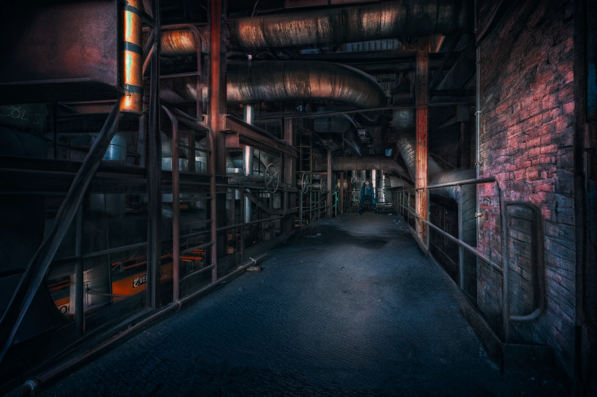a dark room with pipes and a brick wall
