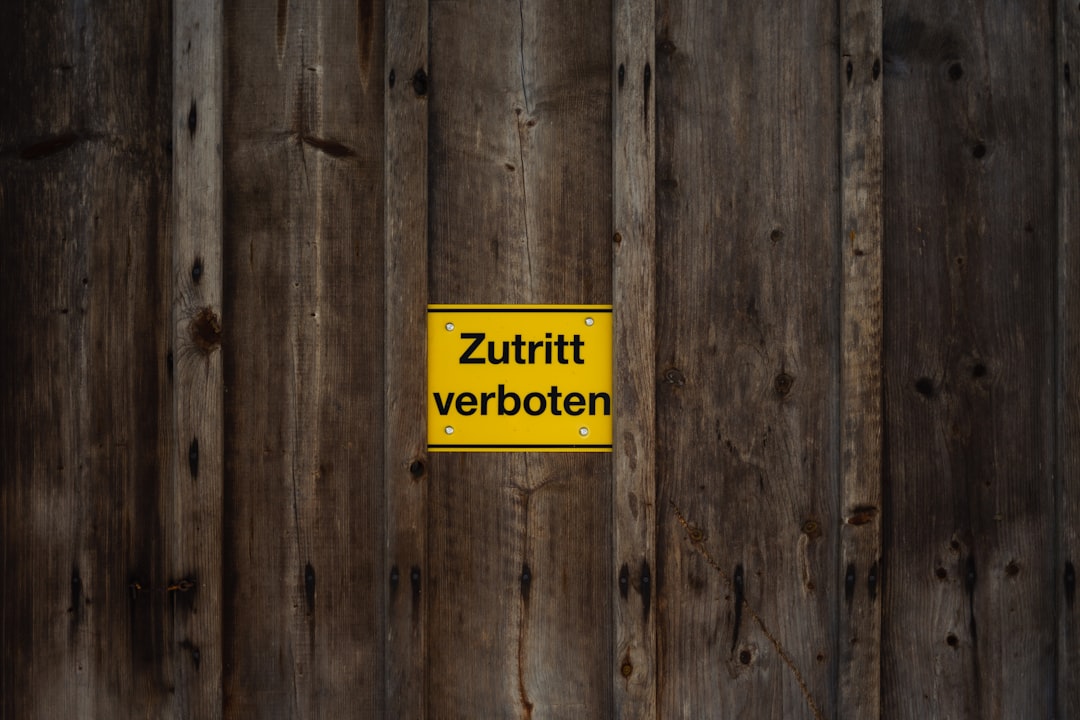 a wooden fence with a yellow sign on it, Ein gelbes "Zutritt verboten" Schild an einer Holzwand