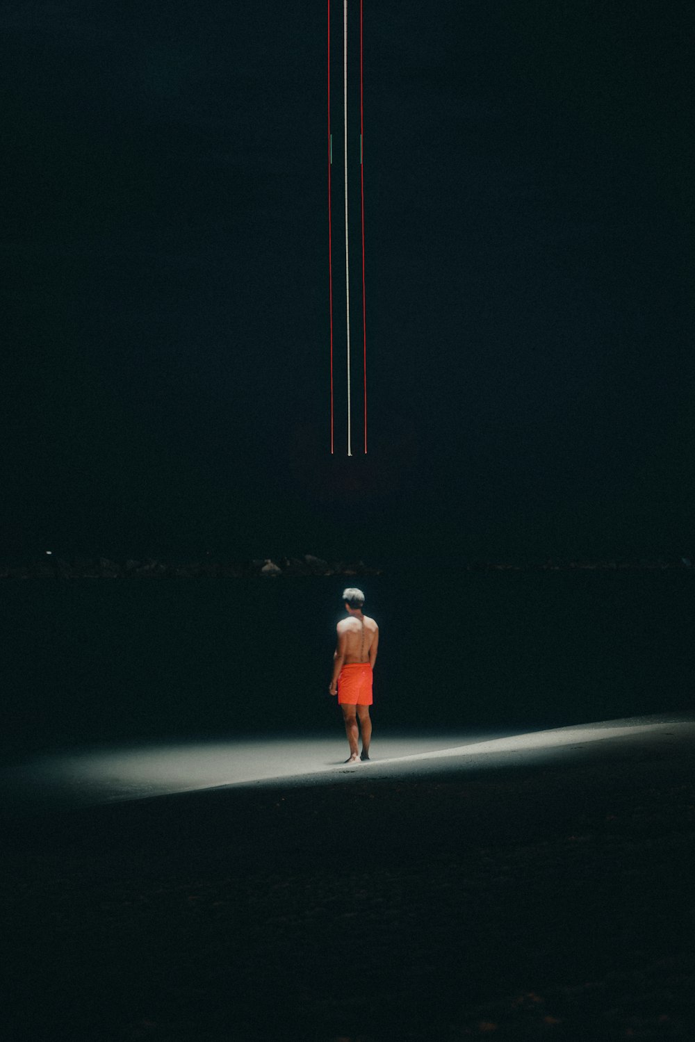 eine Person, die nachts am Strand steht