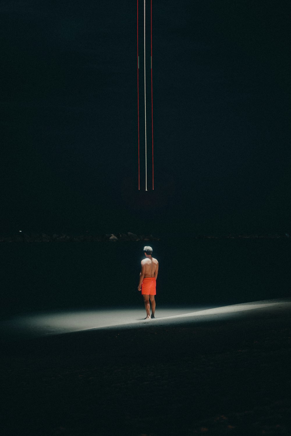 a person standing on a beach at night