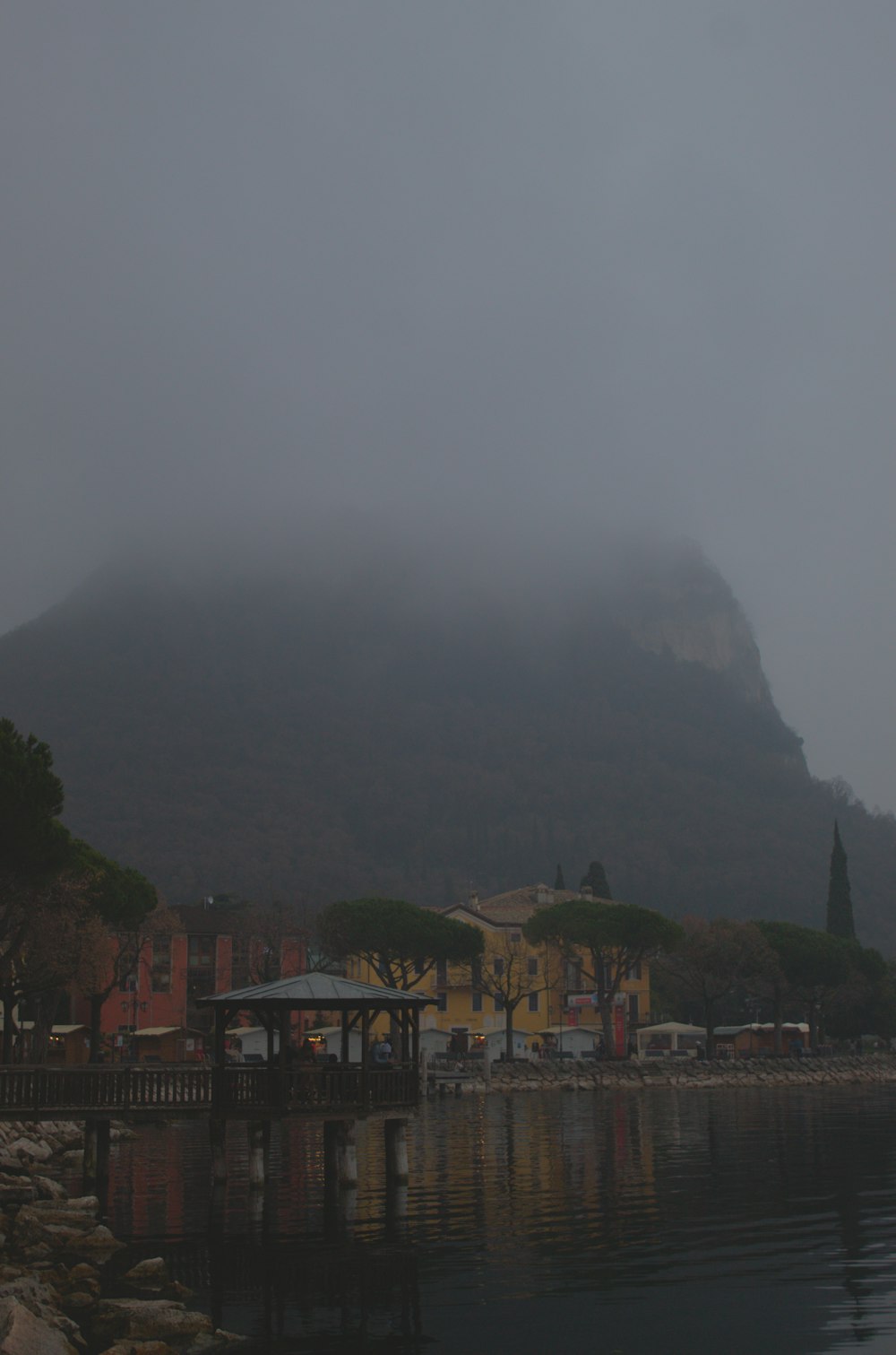 a foggy day on a lake with a mountain in the background