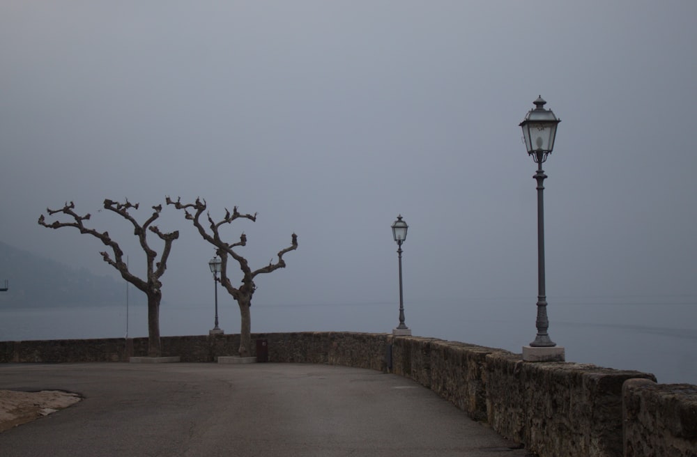 a street light sitting next to a stone wall