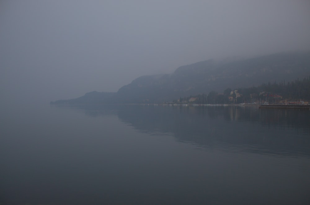 a body of water with a hill in the background