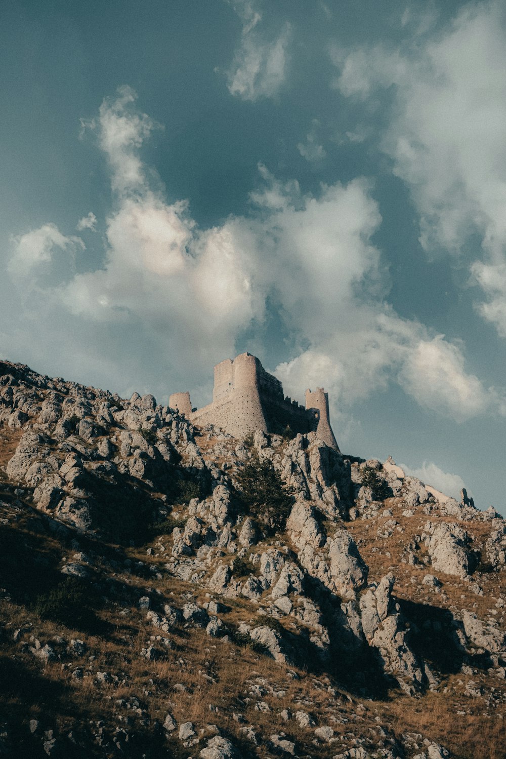 Un castillo sentado en la cima de una montaña bajo un cielo nublado