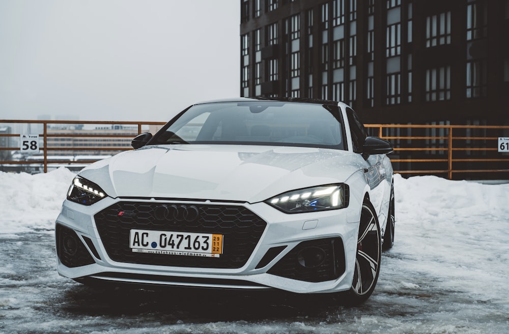 a white car is parked in the snow