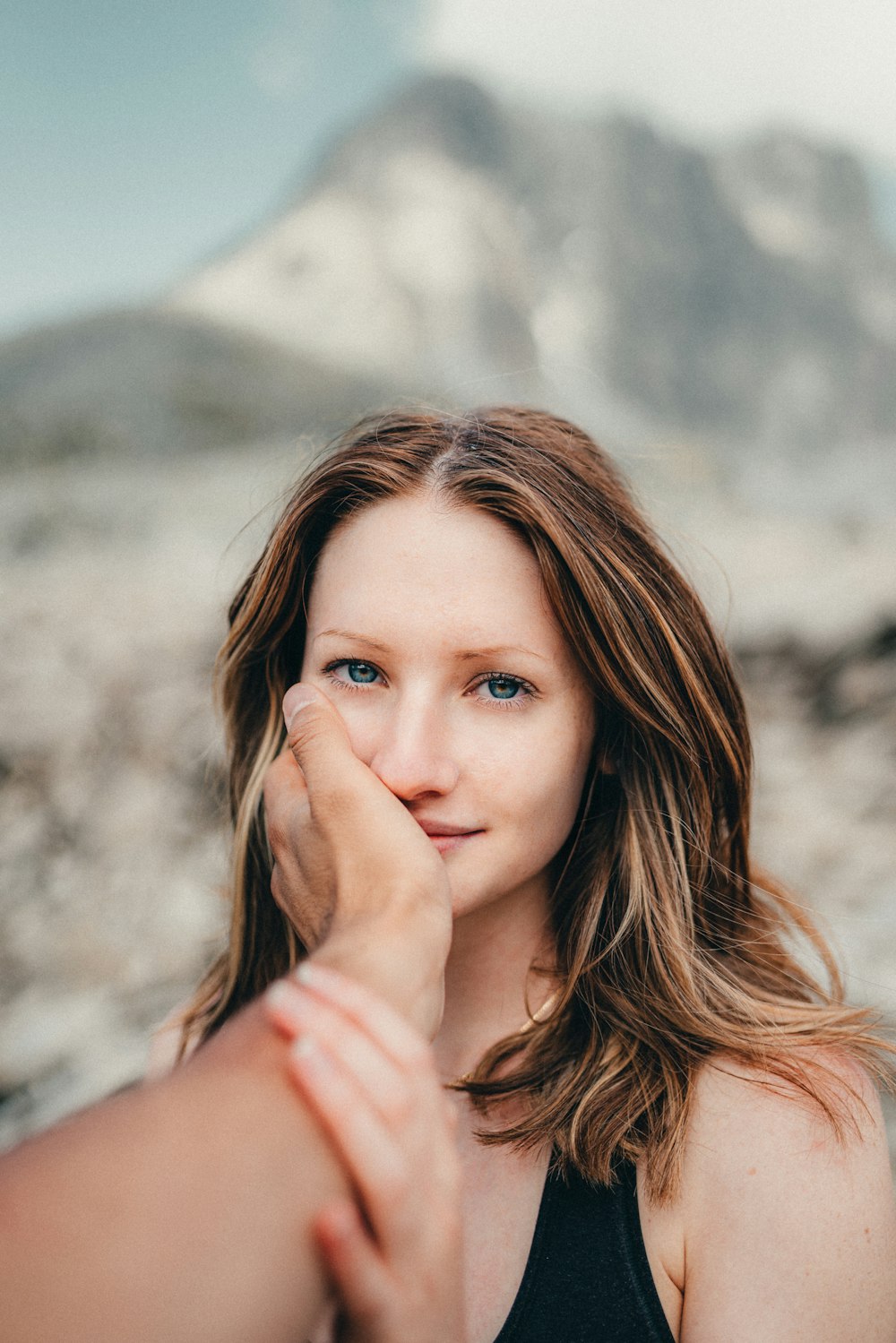 a woman holding her hand up to her face