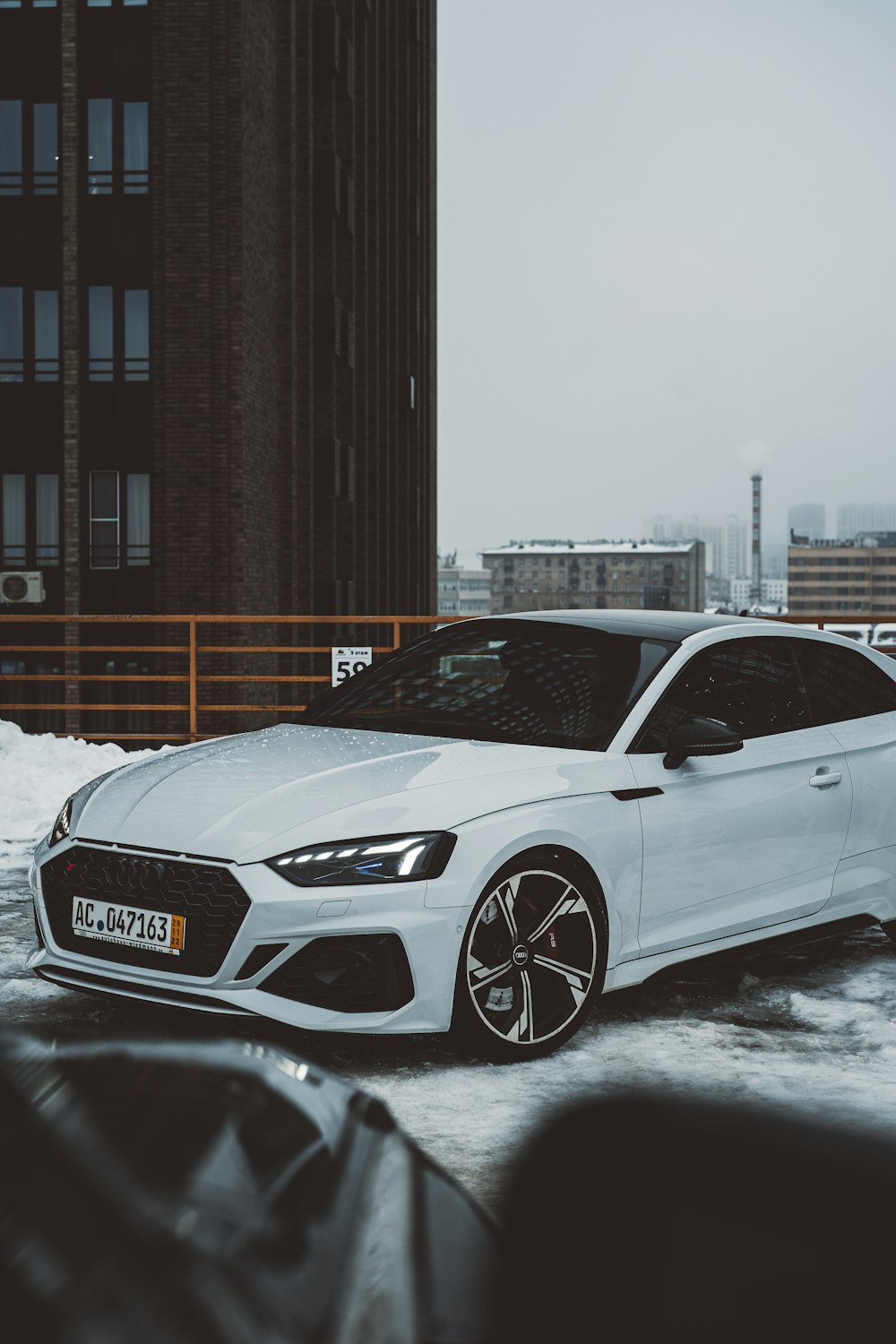 a white car parked in front of a tall building