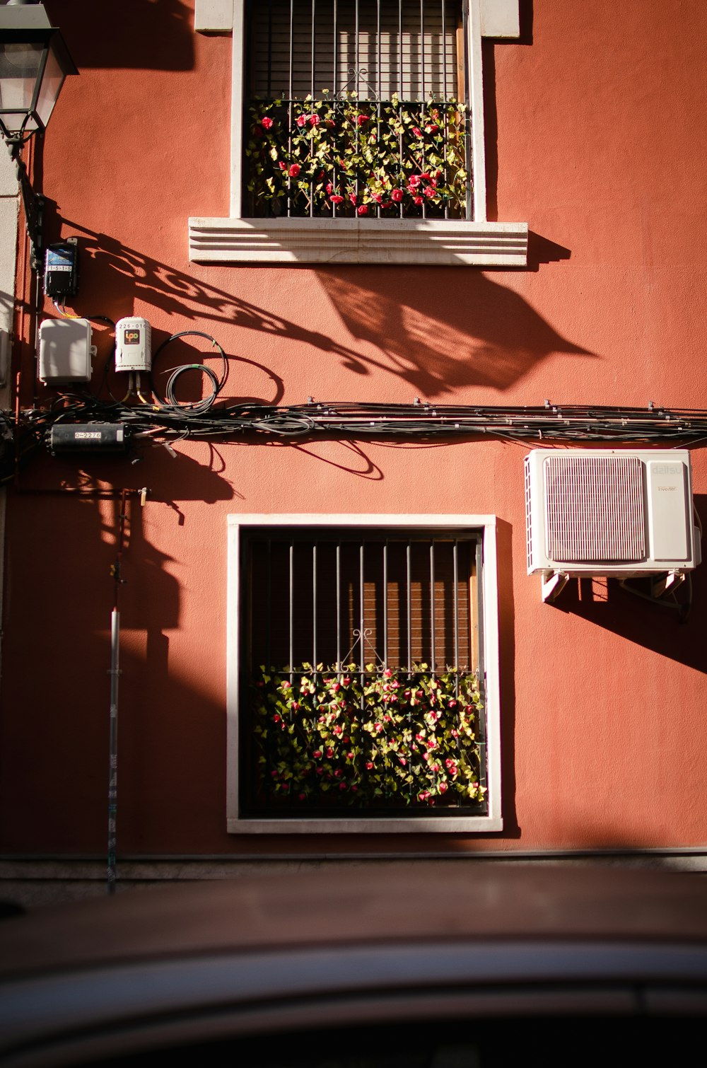 a red building with a window and air conditioner