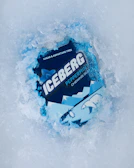 A refreshing burst of mint leaves and vitamin bubbles surrounding a pack of Vitamenthé gums.