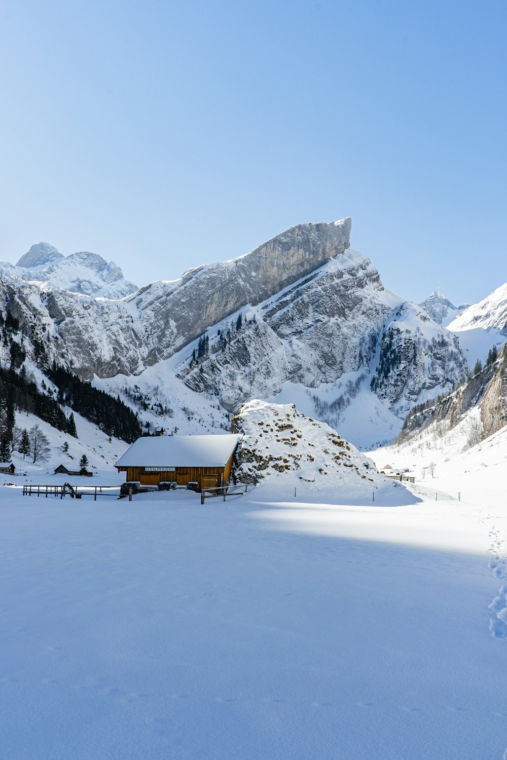 a snow covered mountain with a cabin in the foreground