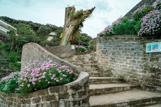 A sturdy brick retaining wall bordering a vibrant garden with stone steps leading up.