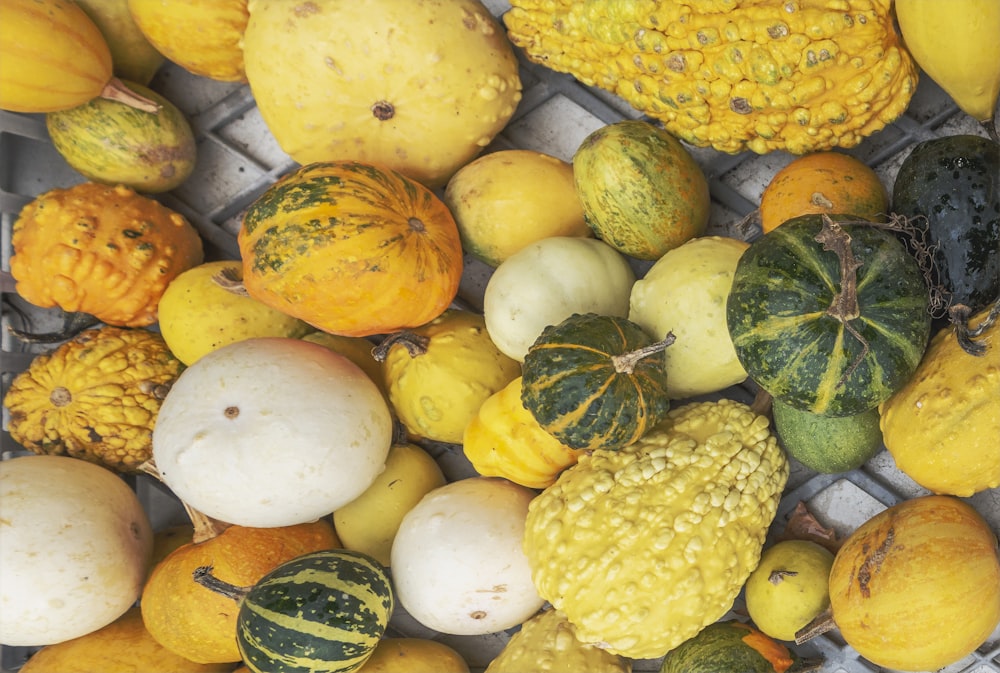 a bunch of squash and gourds sitting on top of each other