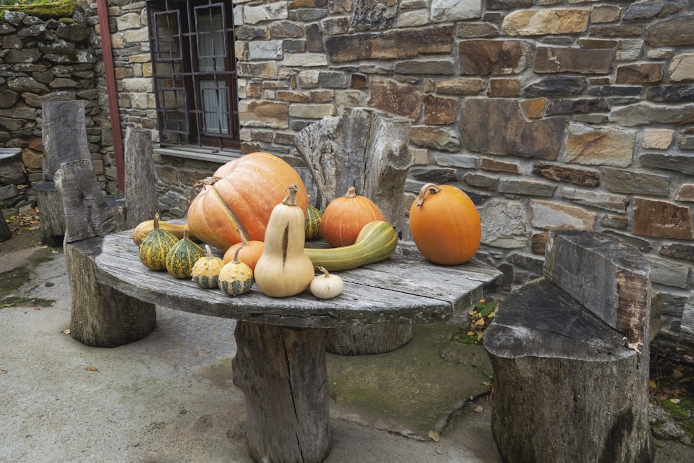 a wooden table topped with pumpkins and gourds