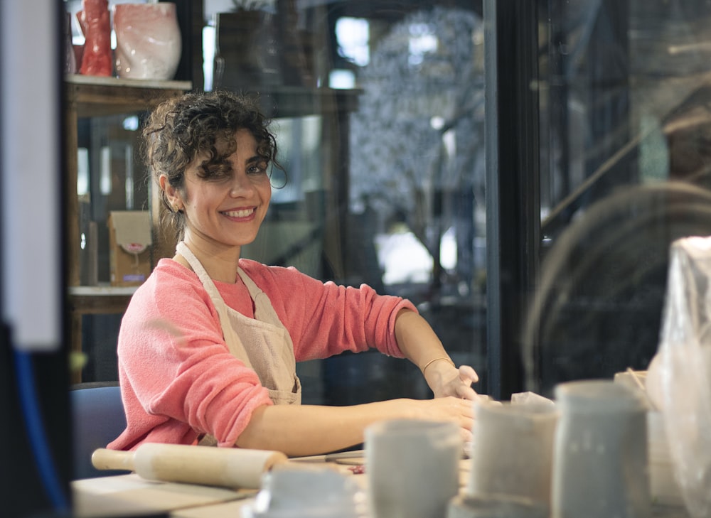 a woman sitting at a table in front of a window