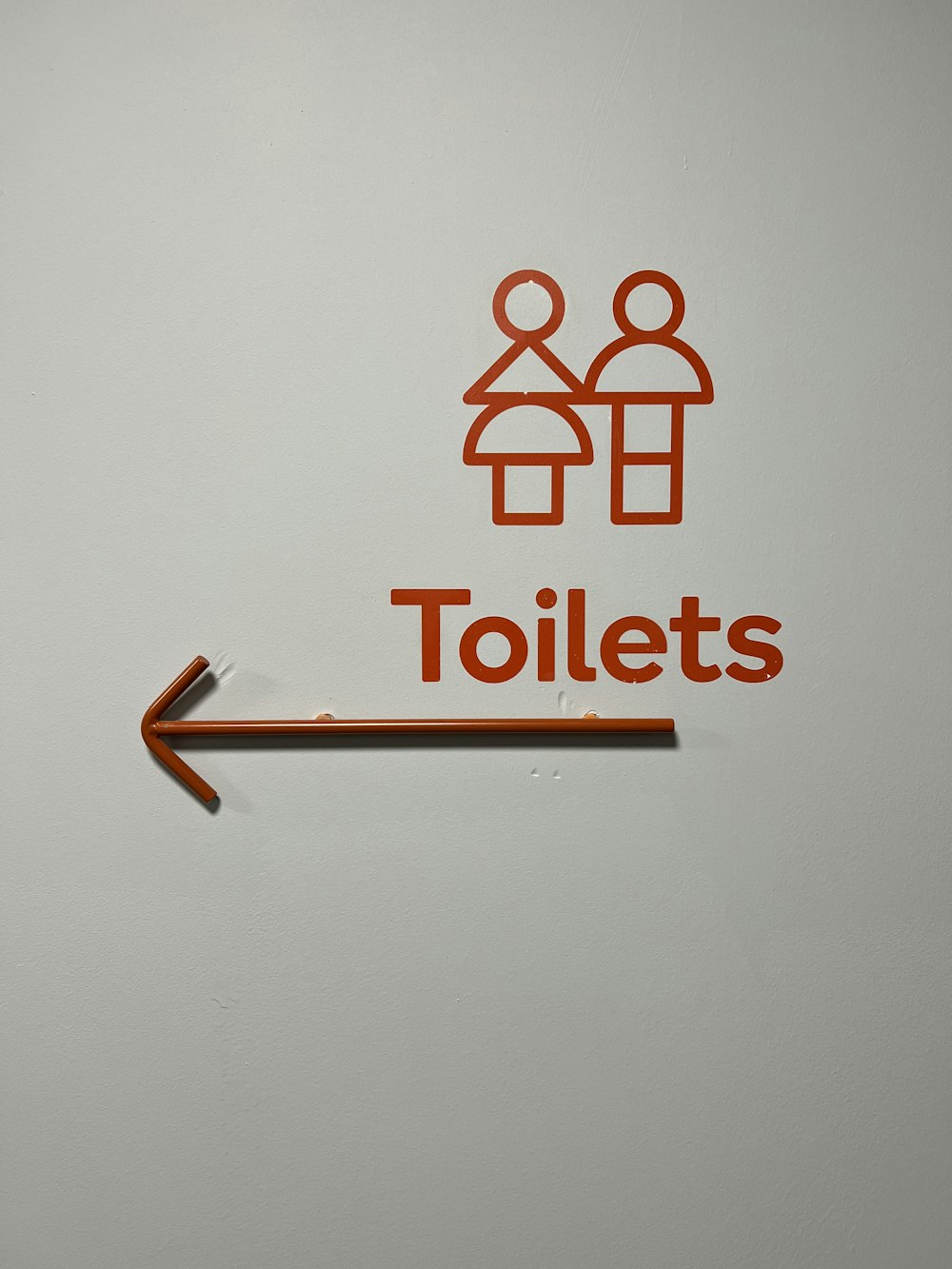 a bathroom sign with an arrow pointing to the toilet