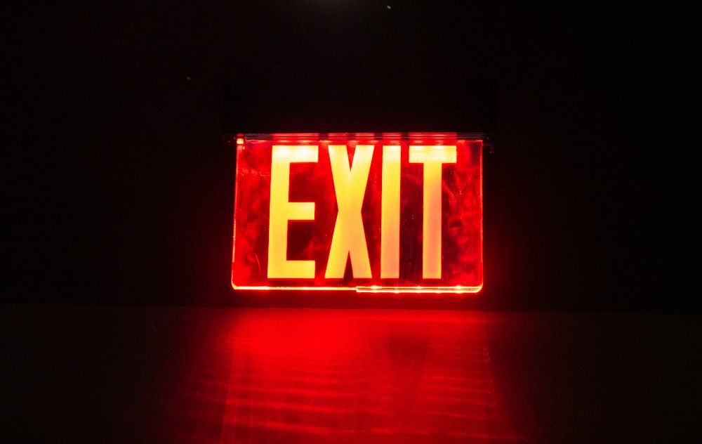 a red exit sign lit up in the dark