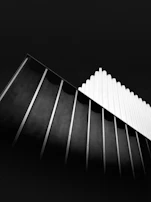 Abstract architectural lines of a modern building, emphasizing shapes and shadows in black and white.