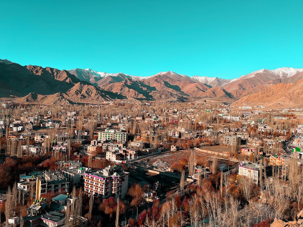 an aerial view of a city with mountains in the background