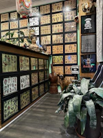 Gallery wall showcasing framed neo-tribal tattoo designs and ceramic art under soft lighting.