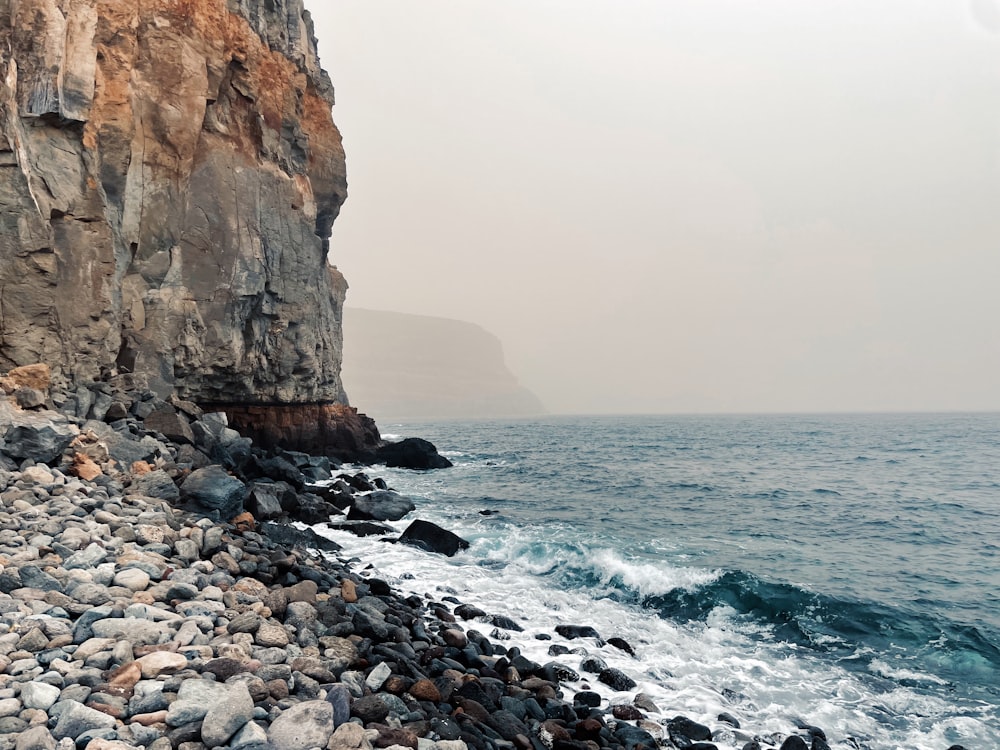 a rocky beach next to a rocky cliff