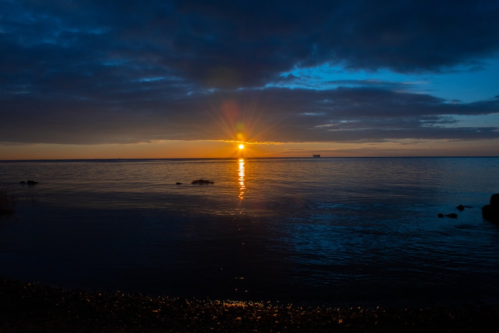 the sun is setting over a body of water