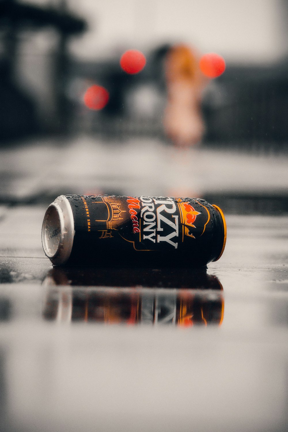 a can of beer sitting on a wet floor