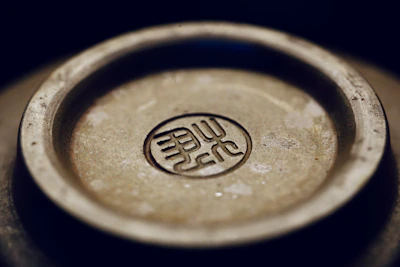 Close-up of a silver GenCon badge with detailed engravings and a polished finish.