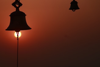 Close-up of the Liberty Bell with the Philadelphia skyline softly glowing at sunset behind it.