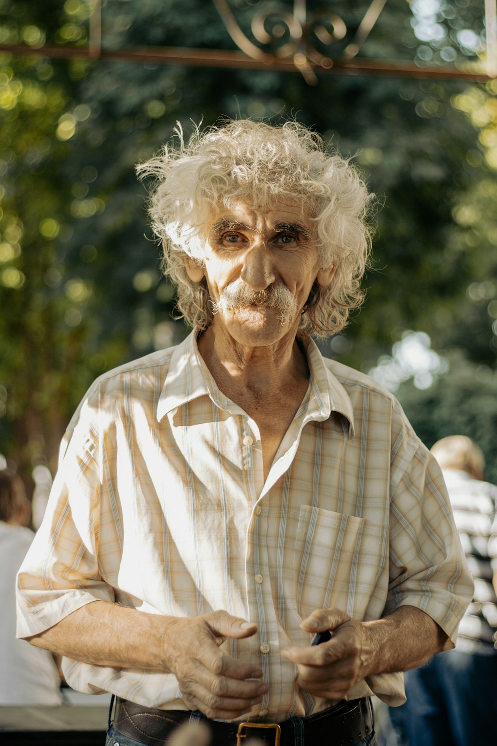 a man with curly hair standing in front of a sign