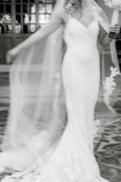 An editorial shot of a model wearing a flowing ivory gown, captured mid-motion with a cinematic blur.
