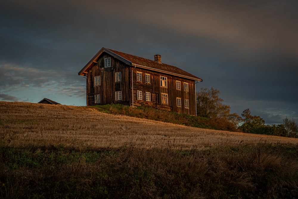 a wooden house sitting on top of a hill