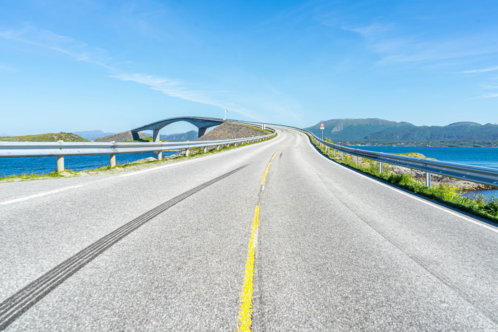 An empty Norwegian road approaching an Atlantic coast bridge