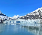 a large glacier with mountains in the background