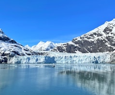 a large glacier with mountains in the background