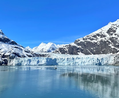 a large glacier with mountains in the background