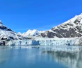 a large glacier with mountains in the background