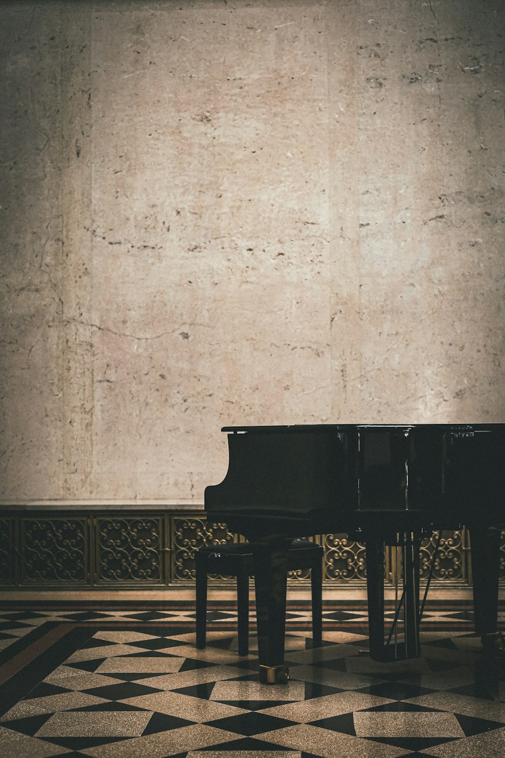 a grand piano in a room with a checkered floor