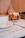 A smiling woman enjoying a cup of coffee with a cinnamon roll at a cozy café table.