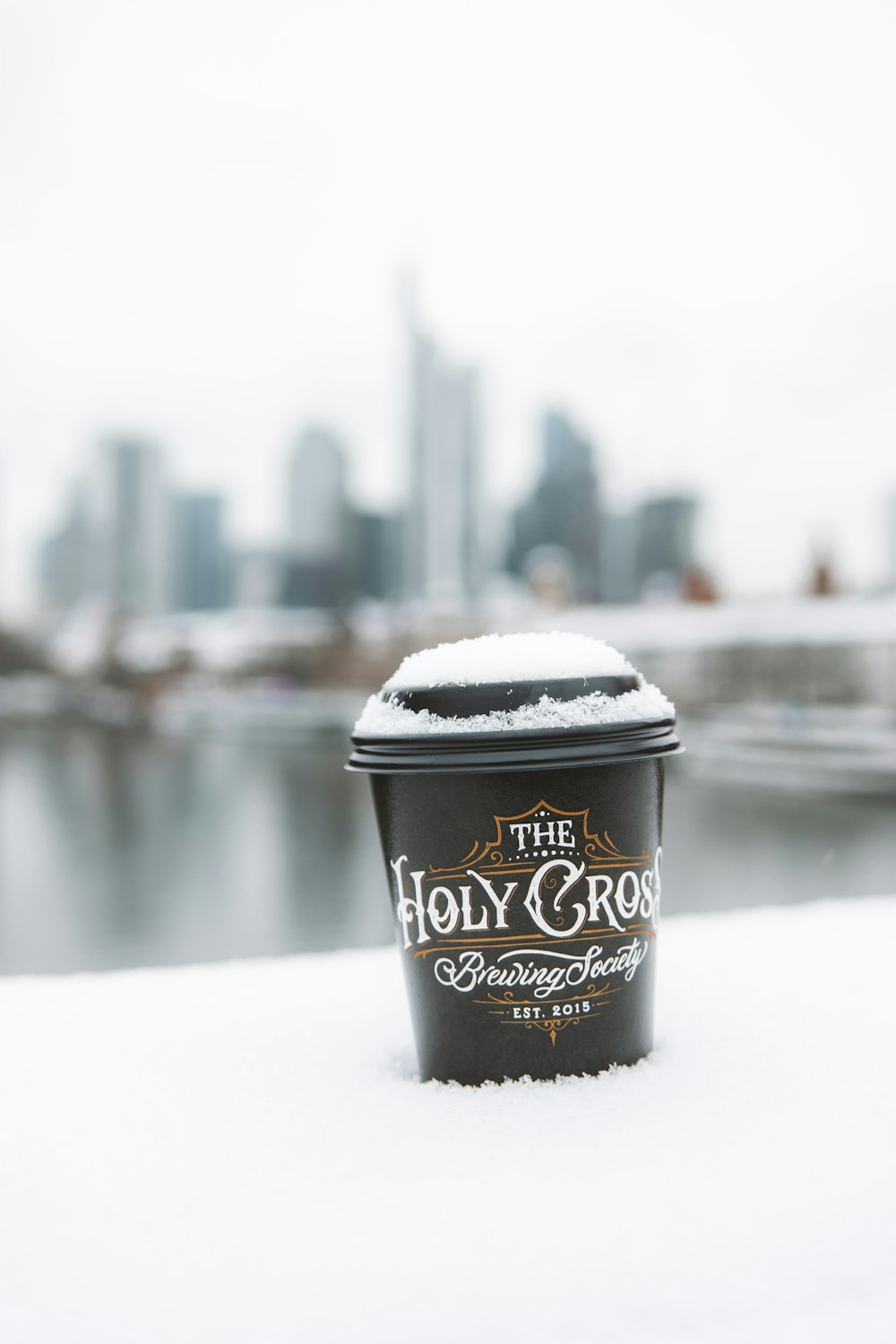 a cup of coffee sitting on top of a snow covered ground