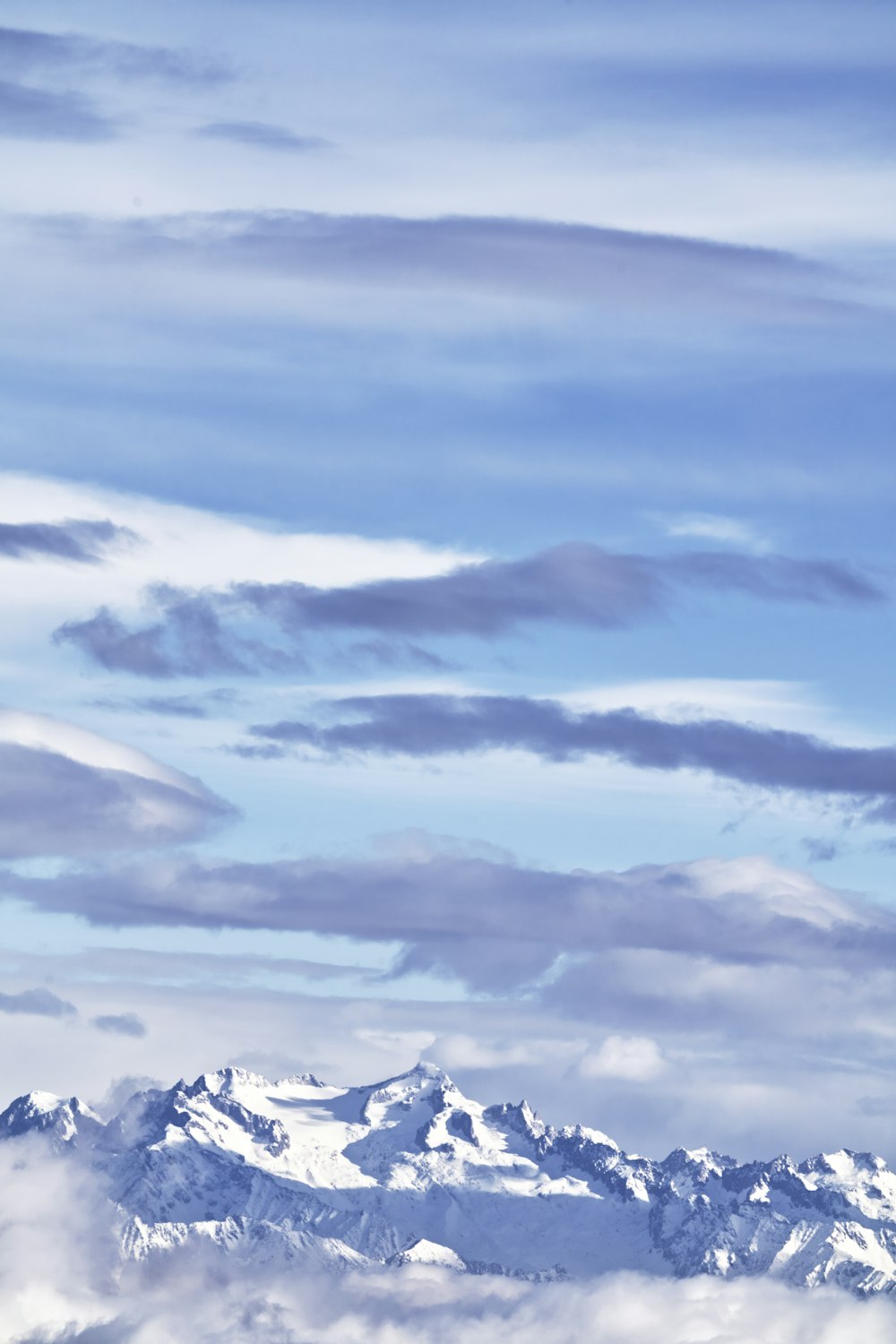 a plane flying in the sky over a mountain range