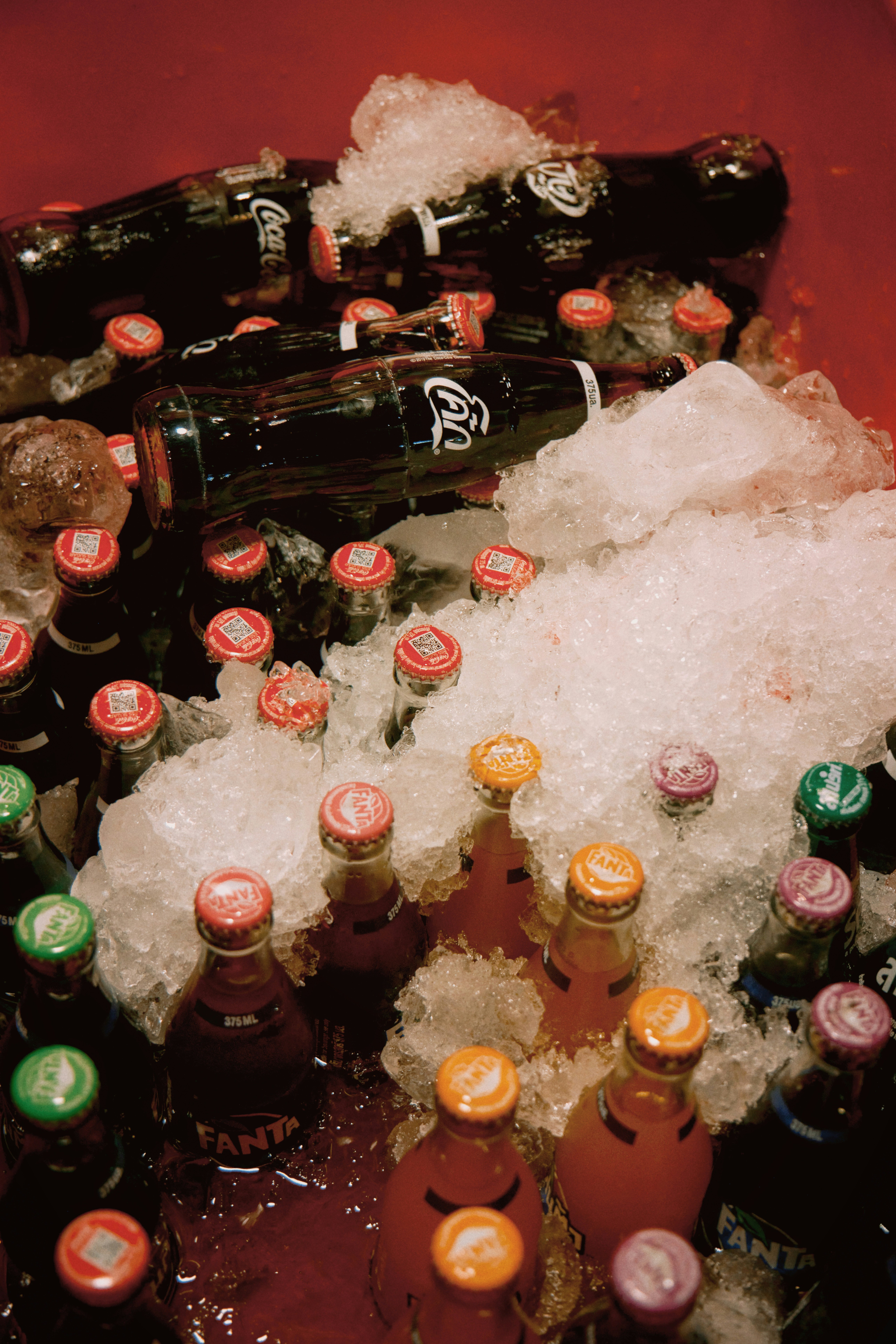 A pile of beer bottles sitting on top of ice photo Free Beverage