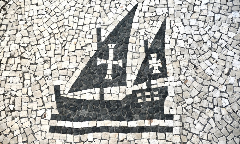 a black and white picture of a sailboat on a mosaic
