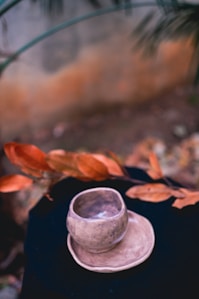 A close-up of a handmade Turkish cup resting on a rustic wooden table surrounded by natural materials.
