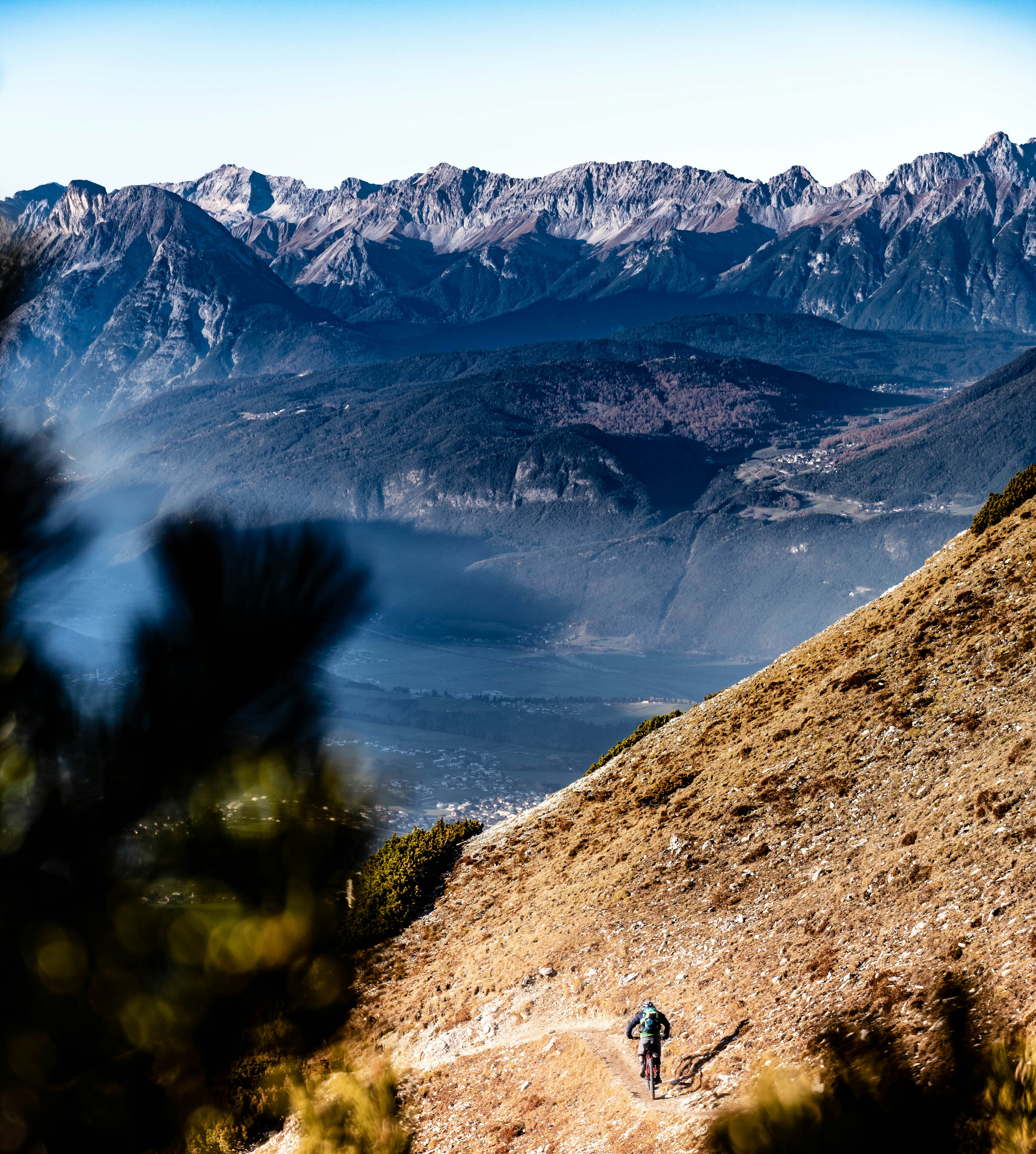 a person walking up a hill with mountains in the background