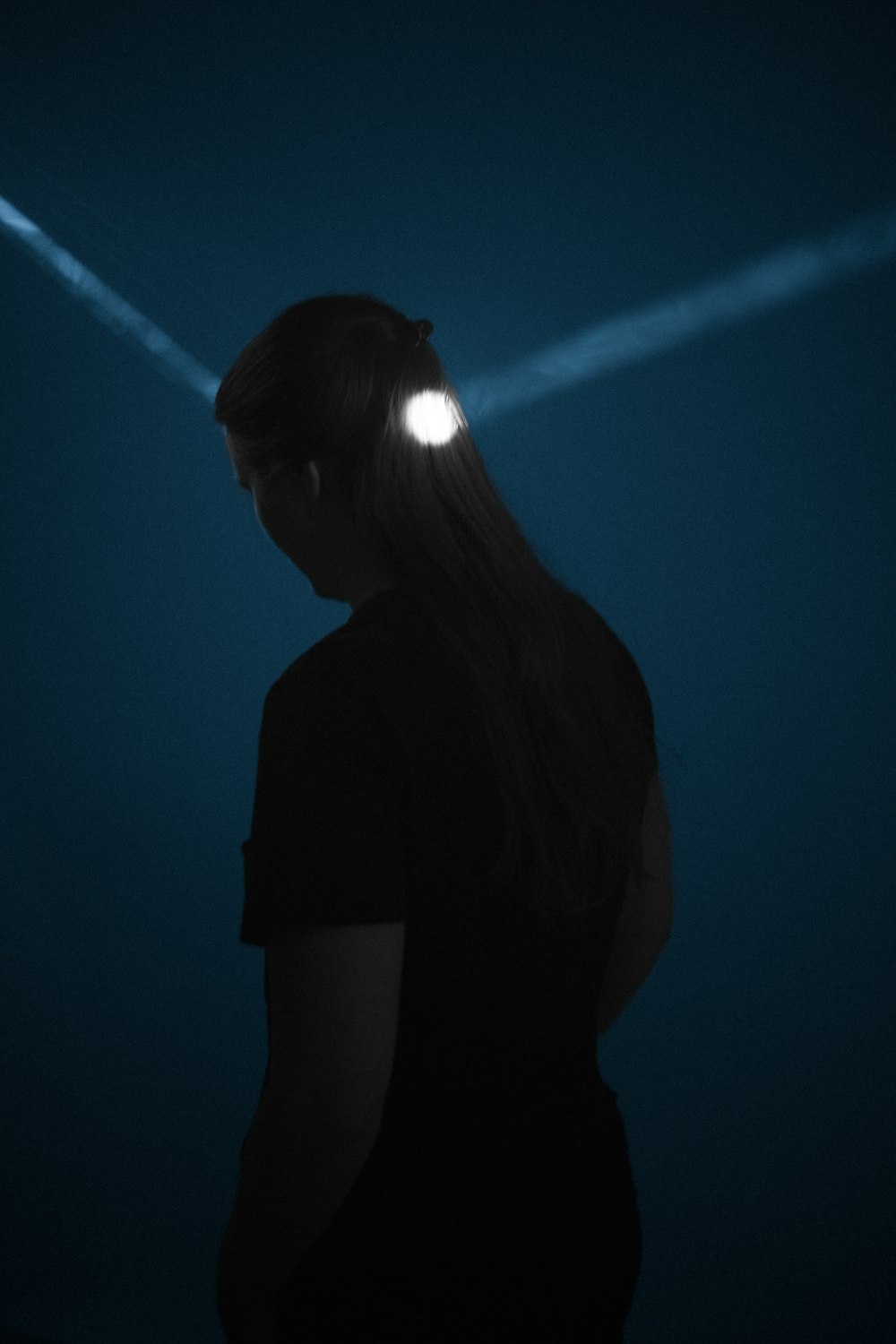 a woman standing in the dark with a flashlight in her head