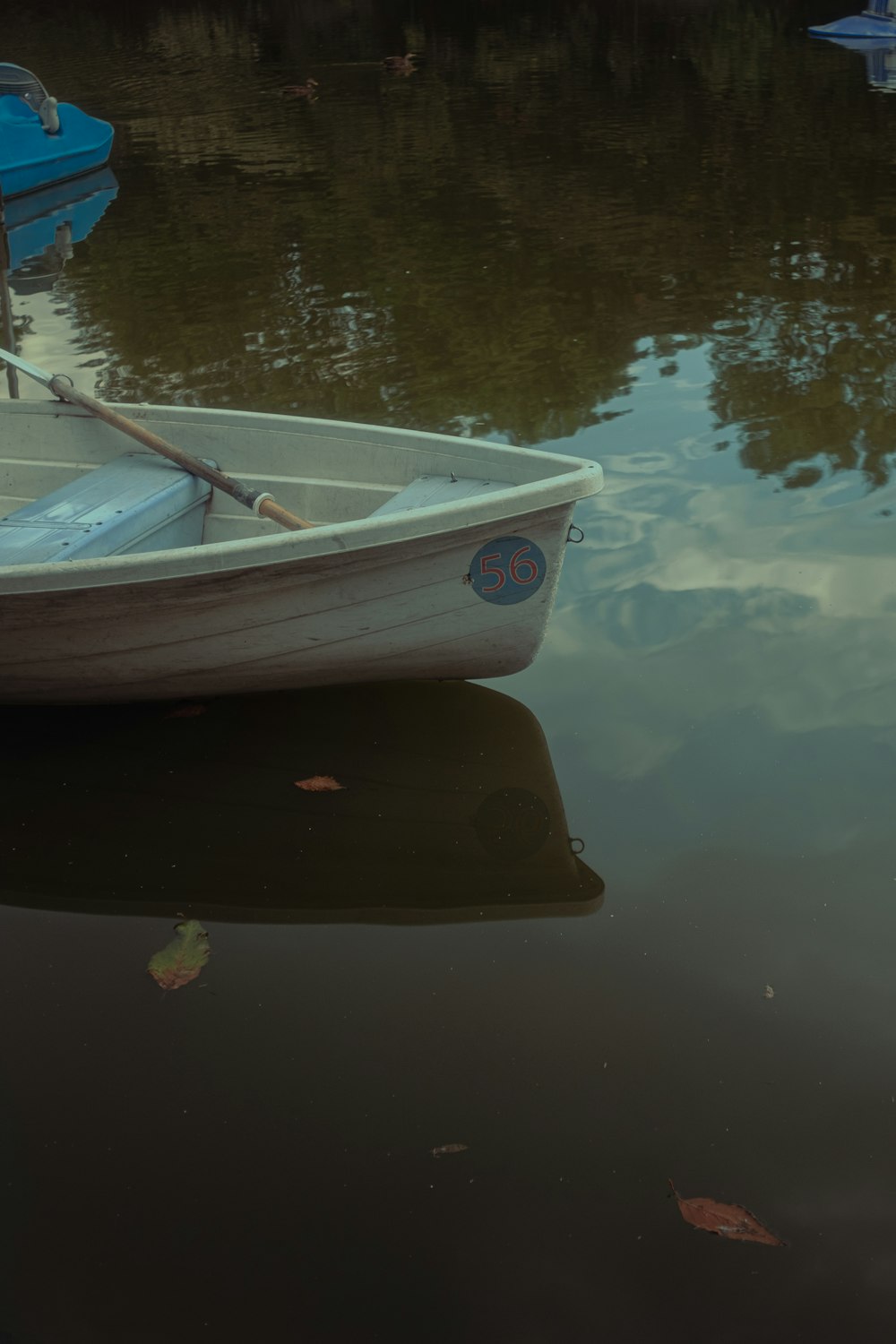 a small white boat floating on top of a lake