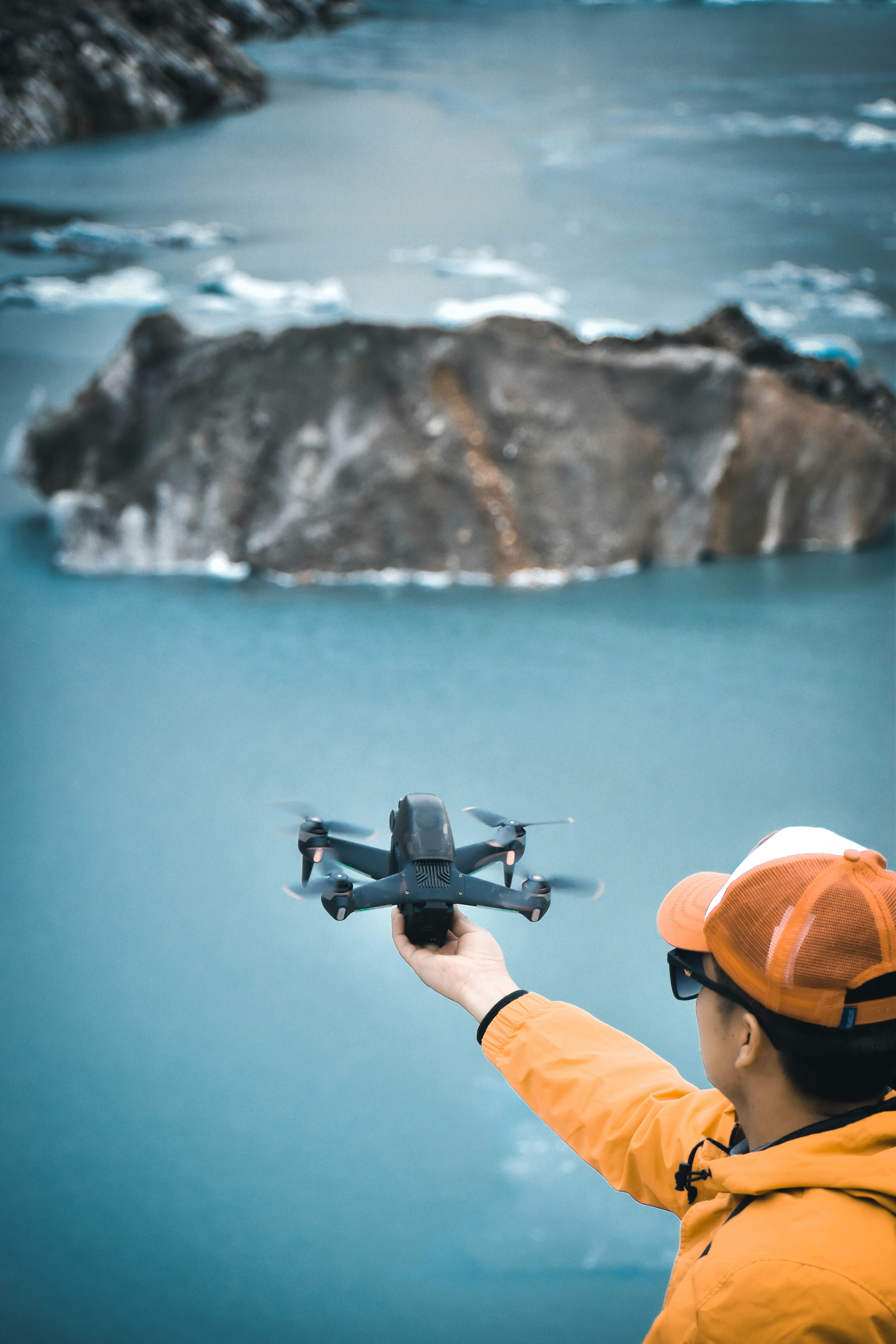 a man holding a remote control plane over a body of water