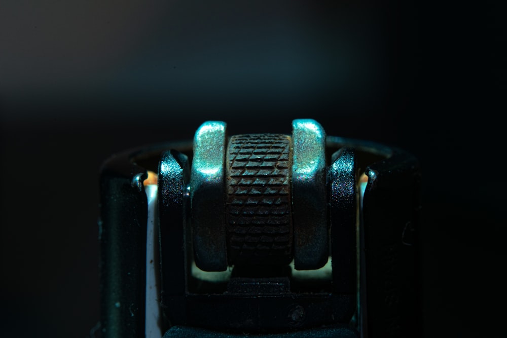a close up of a metal object with a black background