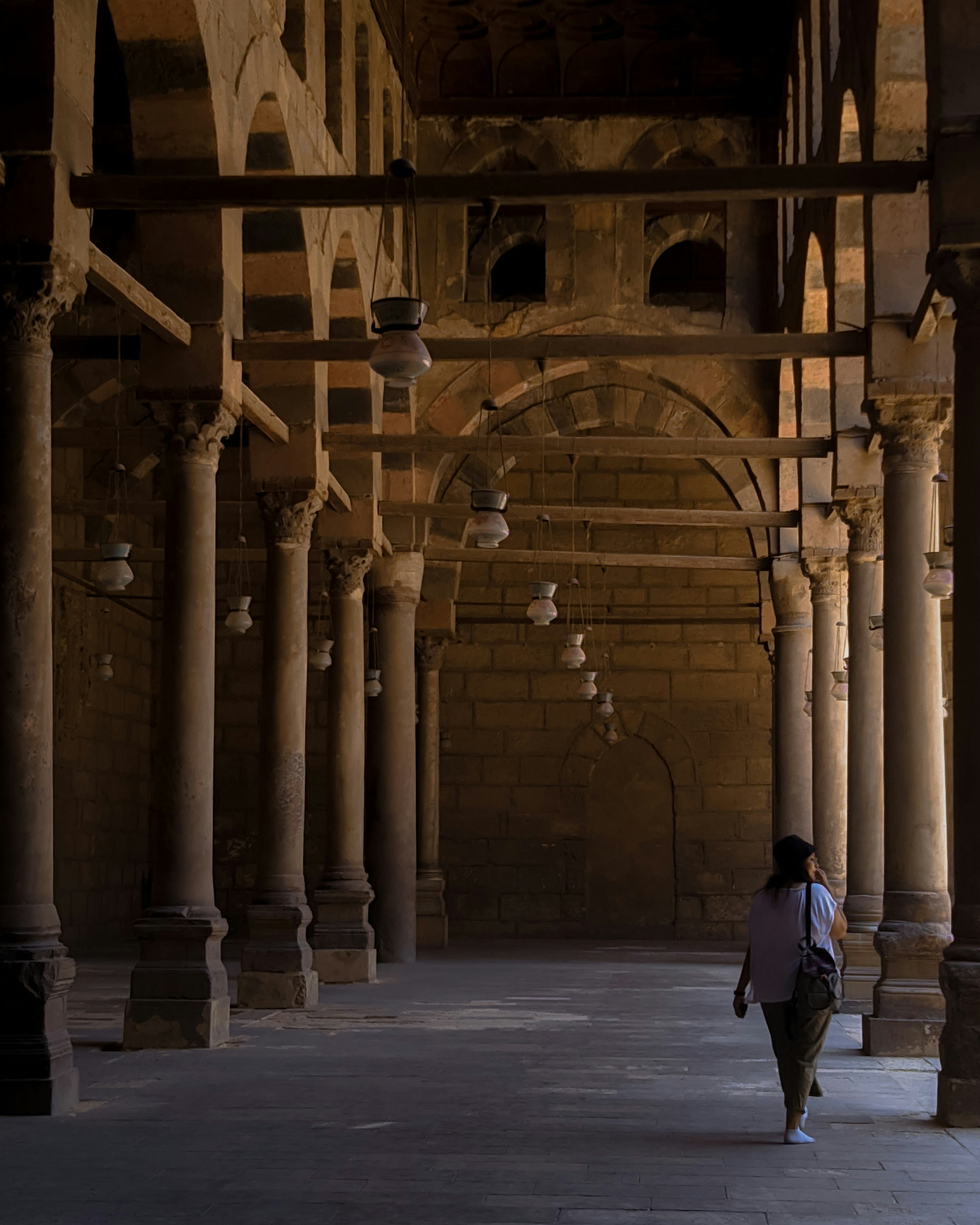 a person walking down a walkway in a building