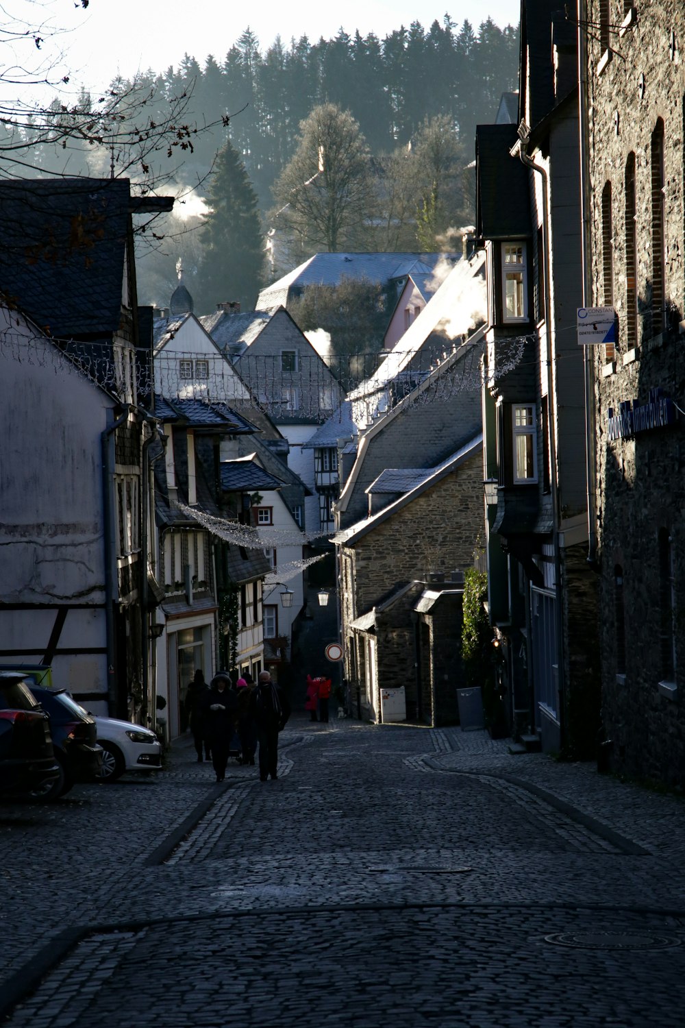 a cobblestone street with people walking down it